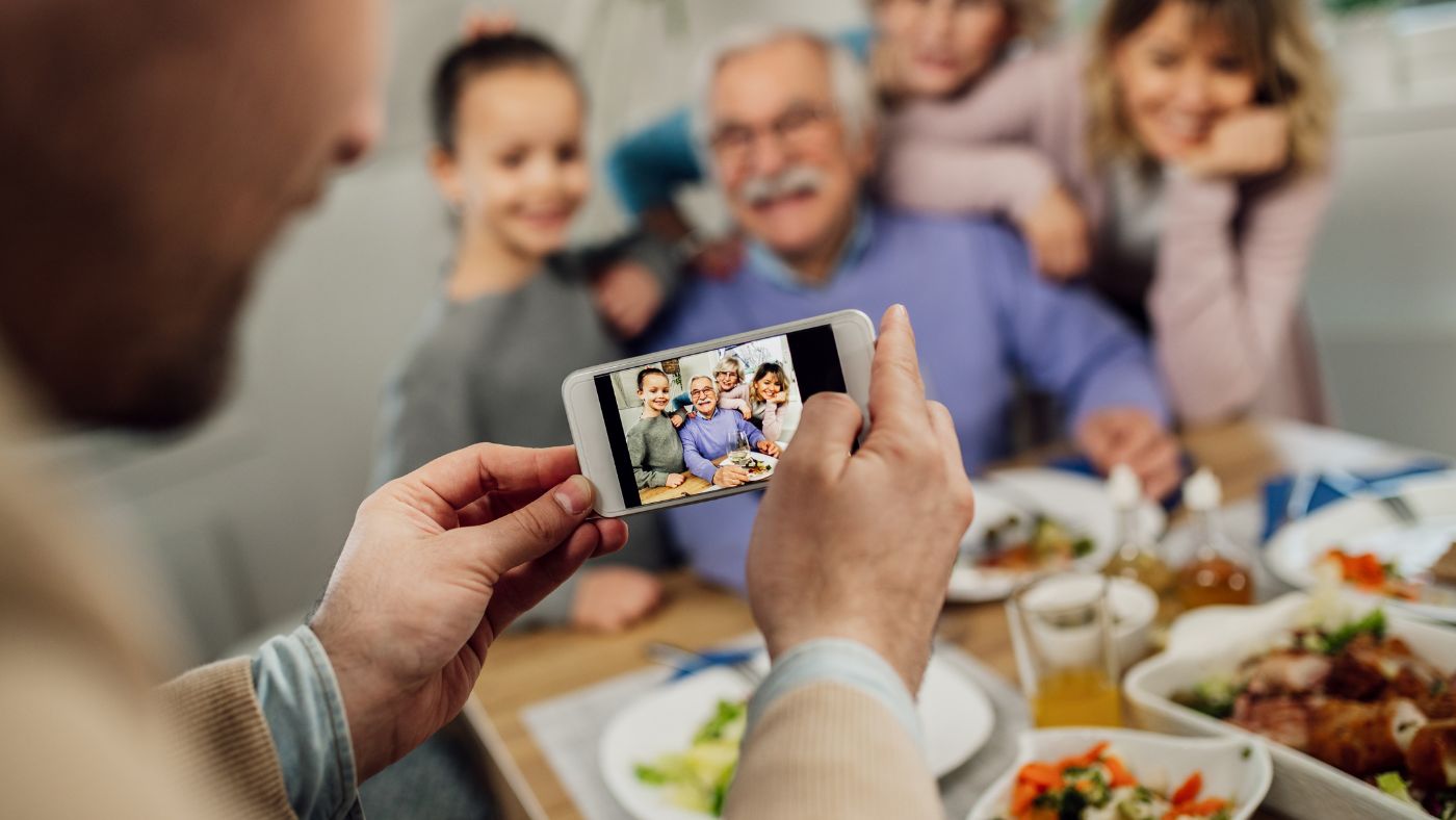 Family capturing a memory around family dinner table. 7 Reasons to Capture a Memory Each Day - Digital Memory Book